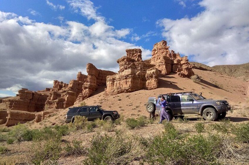 A desert landscape with rock formations and a vehicle. 4