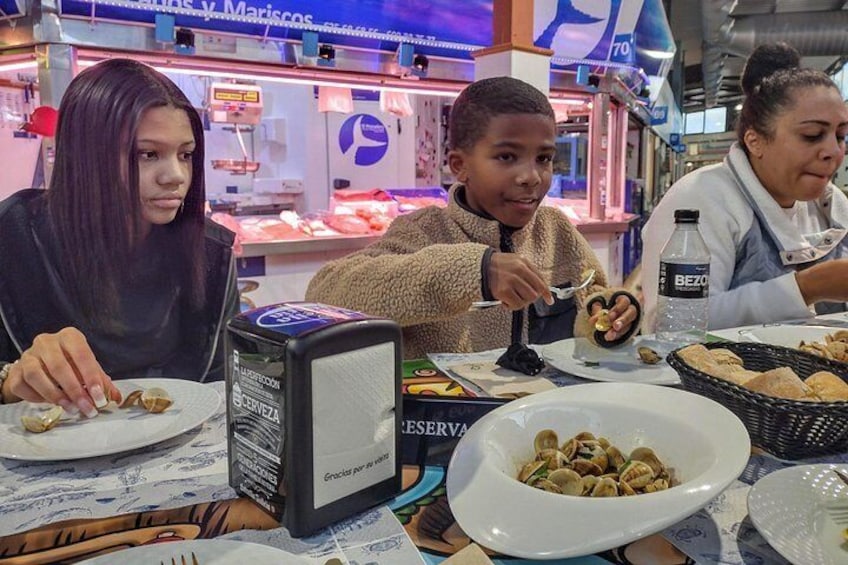 People dining at a seafood restaurant with plates of food and a beverage dispenser. 2
