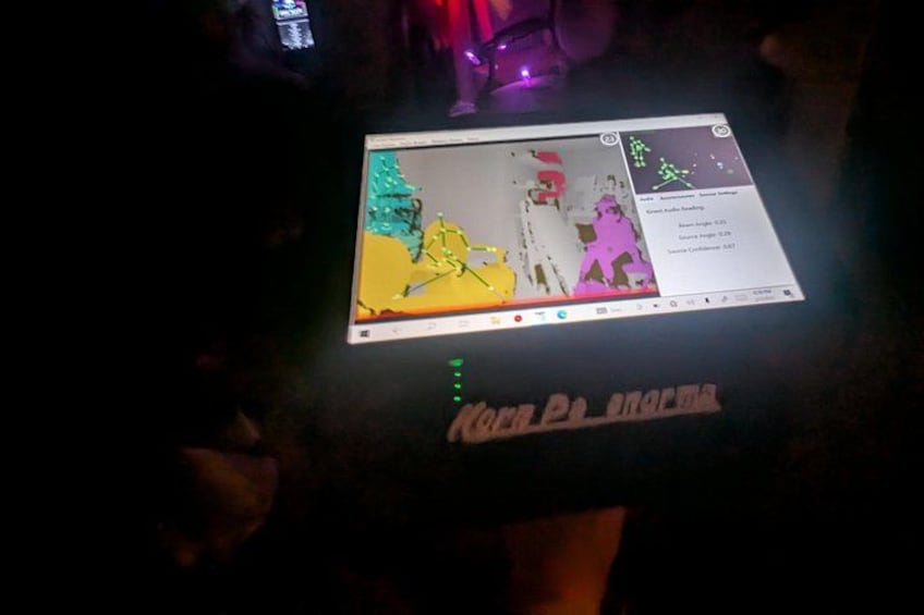 A person holding a tablet displaying a colorful map with a grid overlay. 3