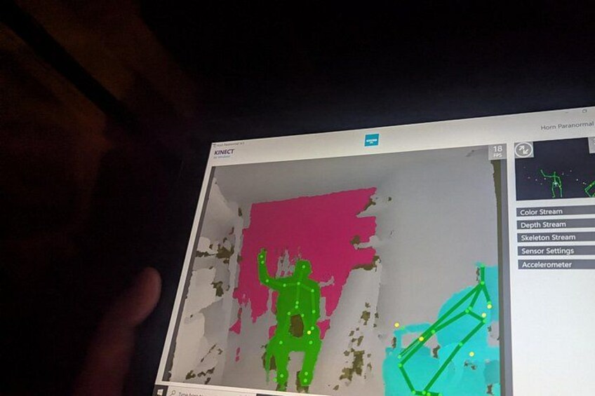 A computer screen with a 3D model of a human figure in green, a pink background, and a blue object. 2