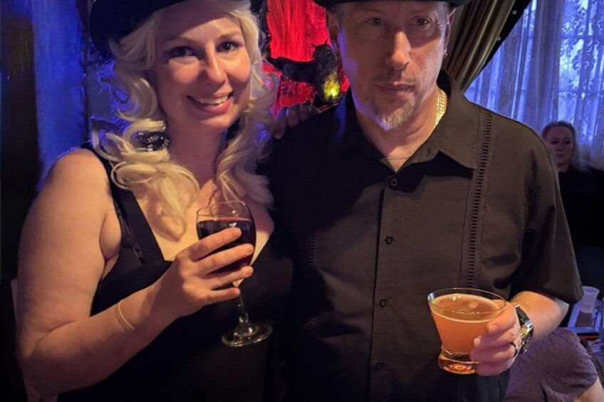Dos personas sosteniendo bebidas en un ambiente interior con poca luz. 4