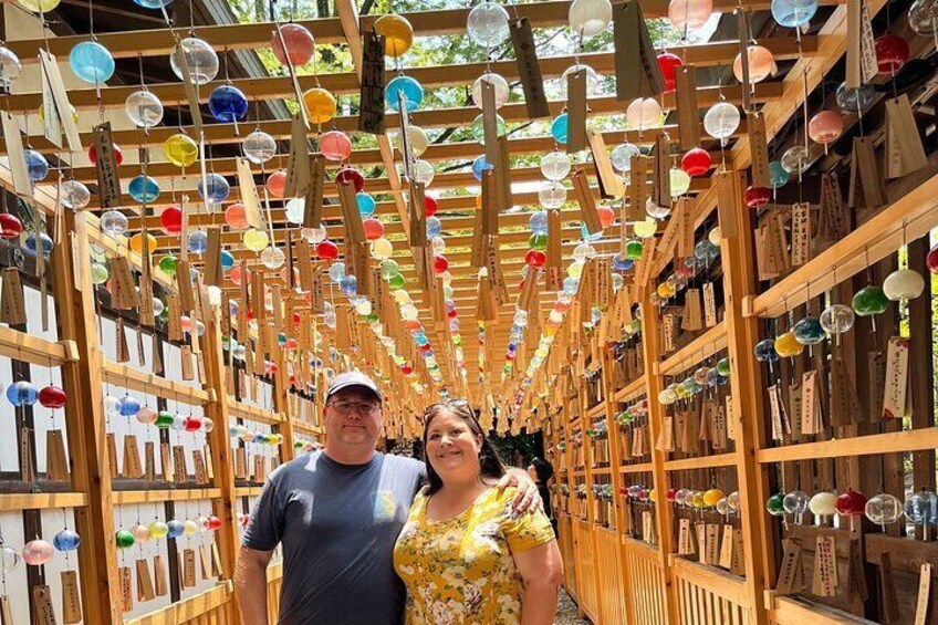 Un pasillo con estantes de madera y esferas de vidrio colgantes en varios colores. 1