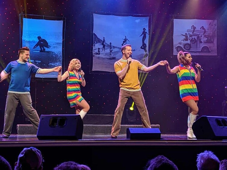 A stage performance with four people in colorful outfits. 2