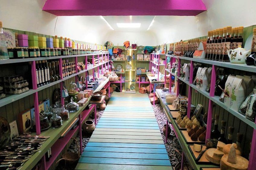 A store with shelves of various items, a central aisle, and a purple ceiling. 4