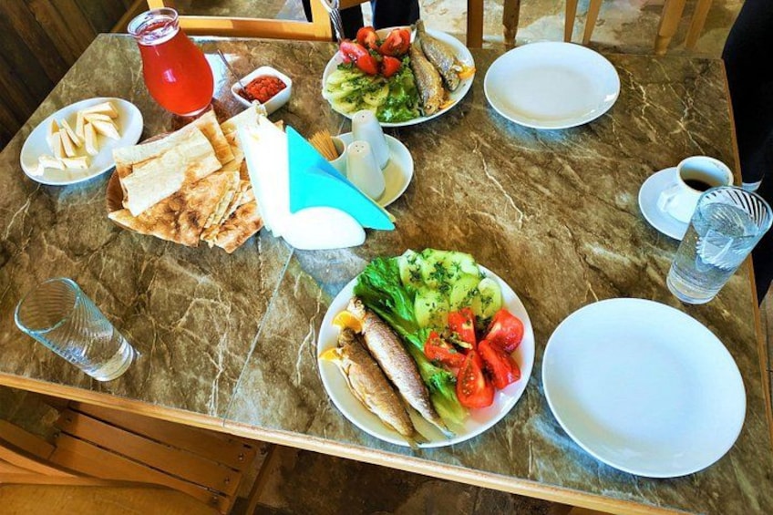 A marble table with various dishes, including fish, salad, and bread. 2