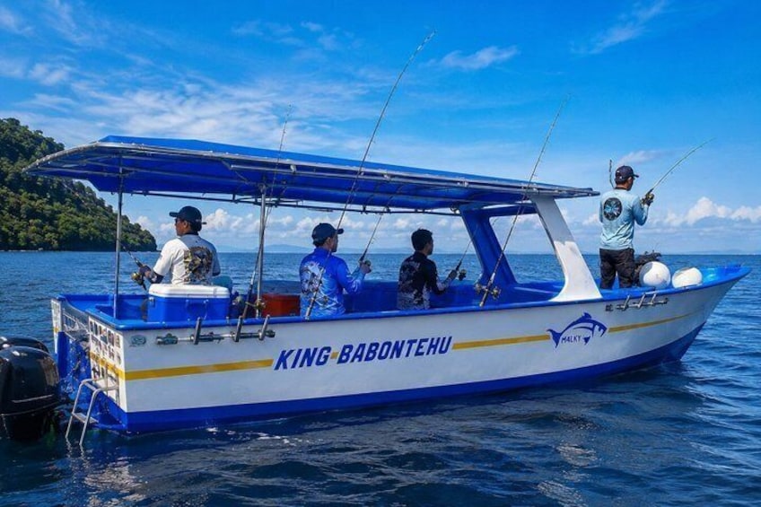 A boat named KING BABONTEHU on calm waters with a clear sky. 1