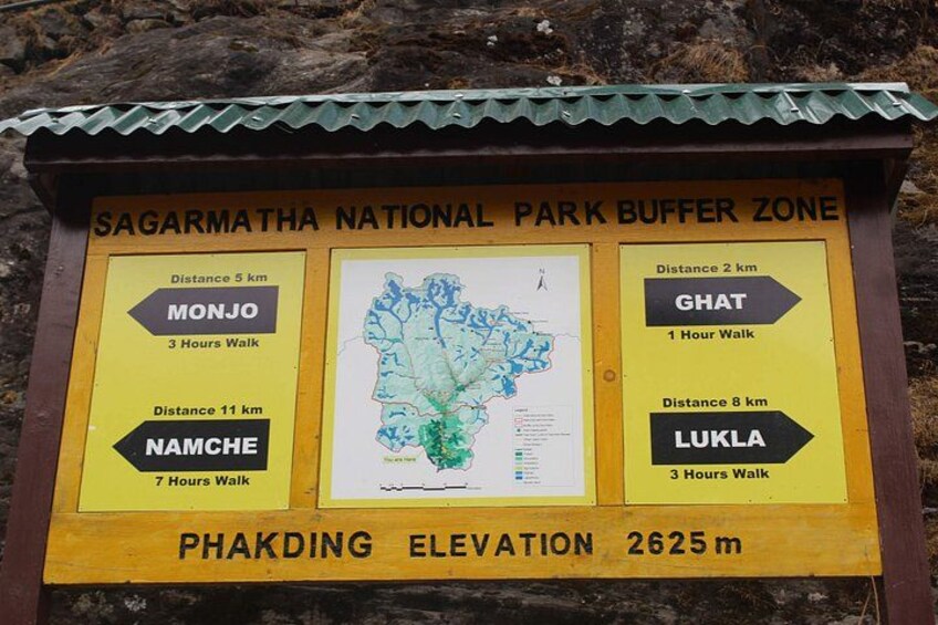 A signboard with directions to various locations within Sagarmatha National Park Buffer Zone, including distances and walking times. 2