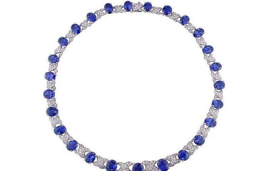 A circular blue gemstone necklace with white diamonds. 4