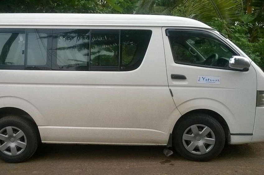A white van parked on a street with a 'Yatours' sign on the side. 2