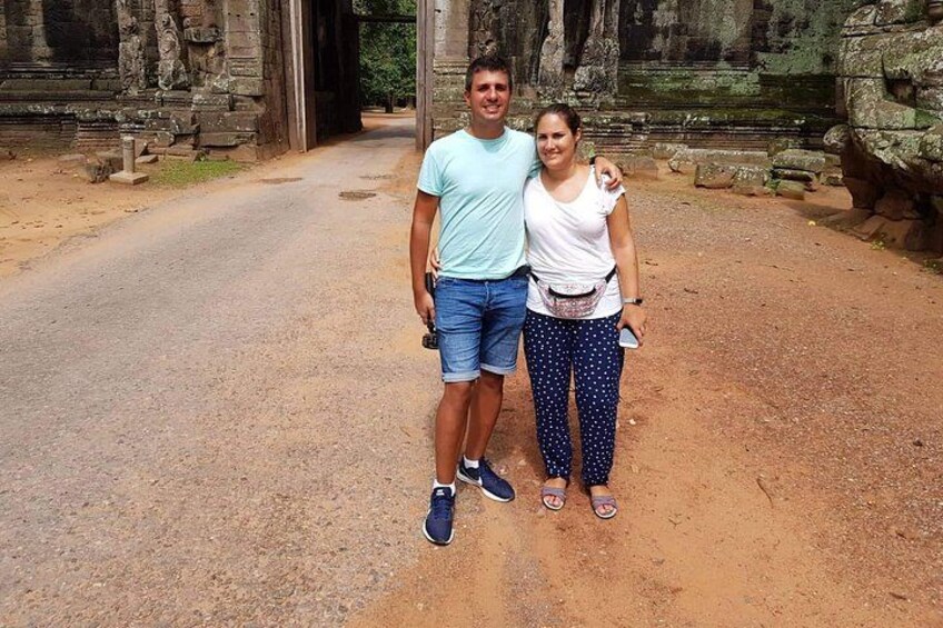Two people standing in front of ancient stone structures. 5