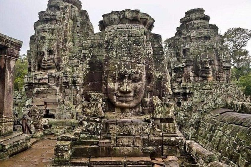 Ancient stone structures with large faces, likely part of a historical temple complex. 5