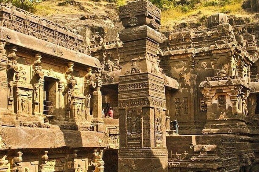 Ancient stone architecture with intricate carvings and a prominent central pillar. 1