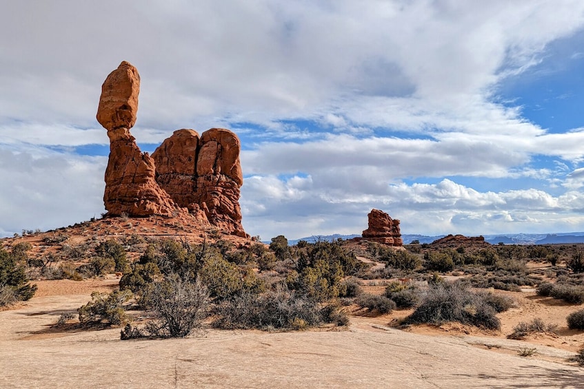 Paisaje desértico con formaciones rocosas rojas destacadas y vegetación escasa. 5