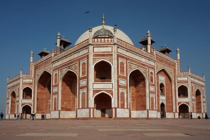 A large, red and white marble building with domes and arches. 4