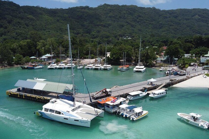 A marina with boats docked, a pier, and a beach. 3