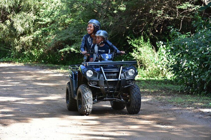 A quad bike on a dirt road surrounded by greenery. 4