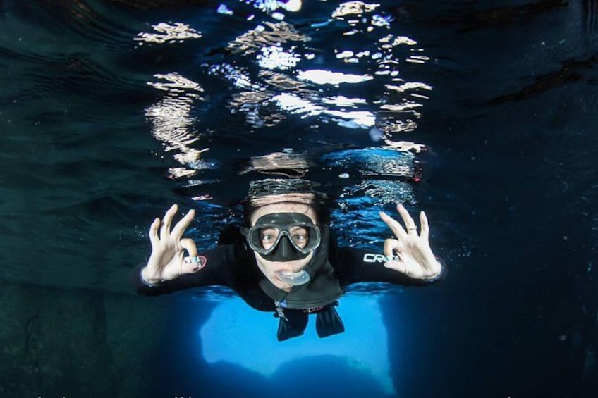 A person underwater, wearing a snorkel and fins, with their hands raised. 4