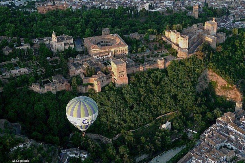 Eine Vogelperspektive einer historischen Stadt mit einem markanten Schloss, einem großen Rundbau und einer Heißluftballon. 3
