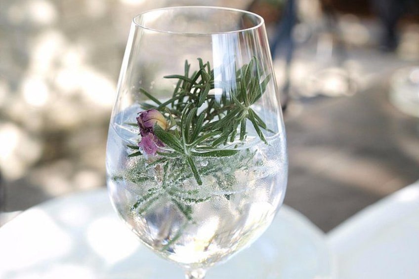 Un vaso con hielo, romero y una flor. 1