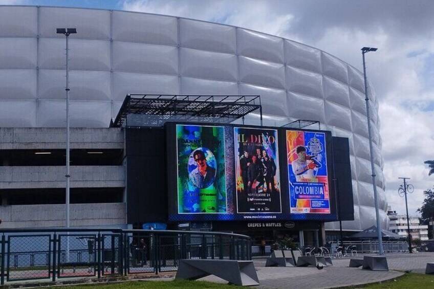 A modern stadium with large digital billboards advertising events. 4