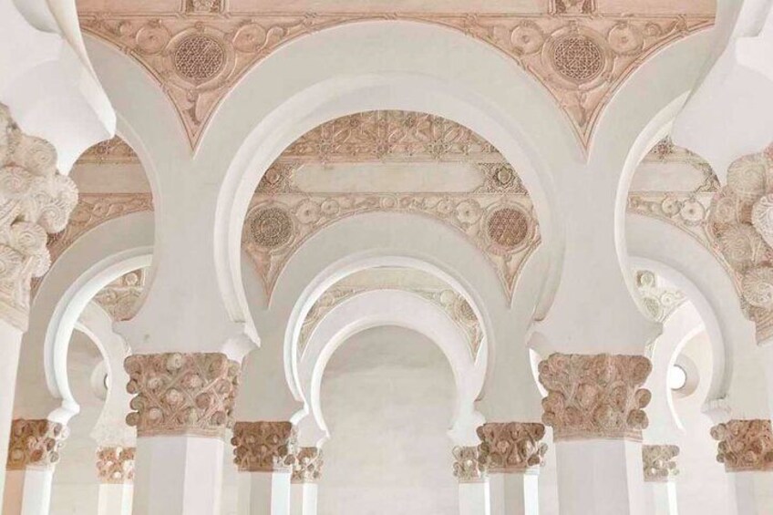 Un techo ornamentado con intrincados diseños florales y arcos. 1