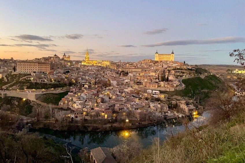 Un paisaje urbano al anochecer con edificios iluminados, un río y una arquitectura histórica destacada. 4