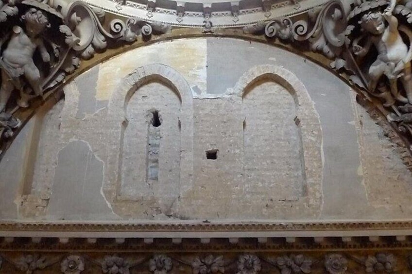 A ceiling with ornate carvings and a central arched opening. 4