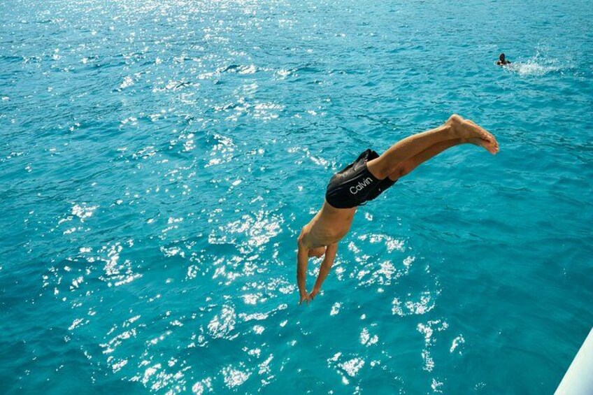 A person diving into clear blue water. 2