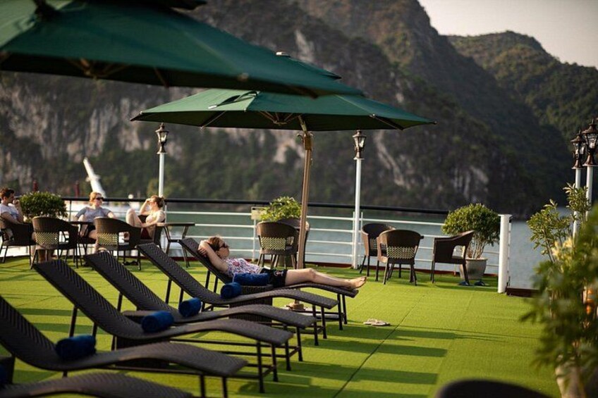 A rooftop terrace with lounge chairs and umbrellas overlooking a mountainous landscape. 3