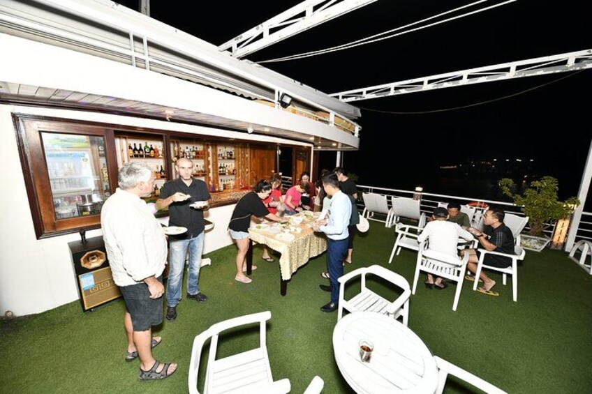 A rooftop bar with people dining and socializing. 5