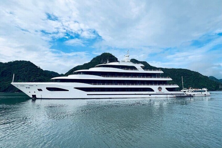 A large white yacht docked on calm waters with a mountainous backdrop. 3