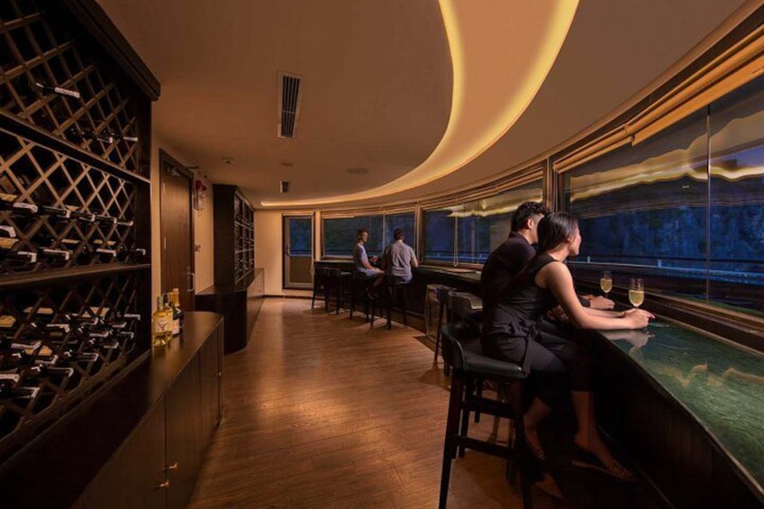 A bar with a wine rack, a bar counter, and a view of the night sky. 4