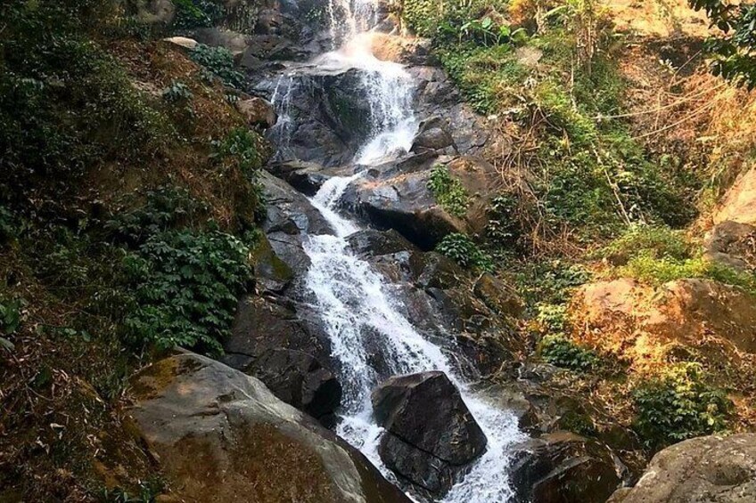 A waterfall cascading over rocks in a forested area. 2