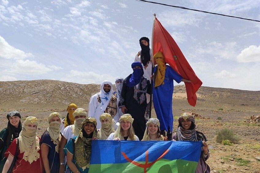 A group of people in a desert landscape holding a flag. 3