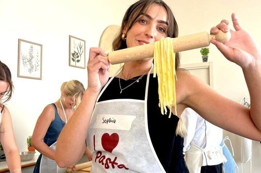 A person making pasta with a rolling pin. 4