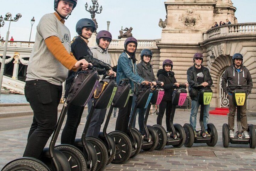 En gruppe mennesker på segways foran en historisk springvand. 3