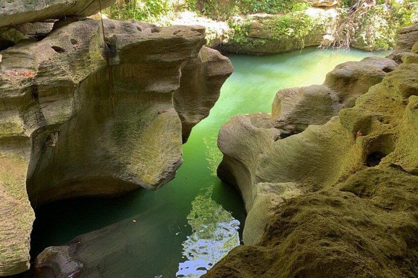 Een natuurlijke rotsformatie met een waterlichaam in groentint. 4