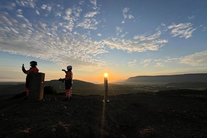 Two people taking a photo of the sunset on a mountain. 3