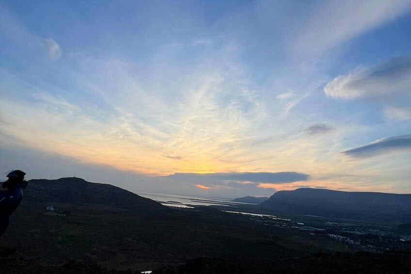 A landscape with a river, hills, and a person standing on a hill. 2