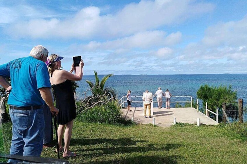 A coastal walkway with people walking and taking photos. 2