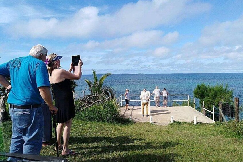 A coastal walkway with people walking and taking photos. 2