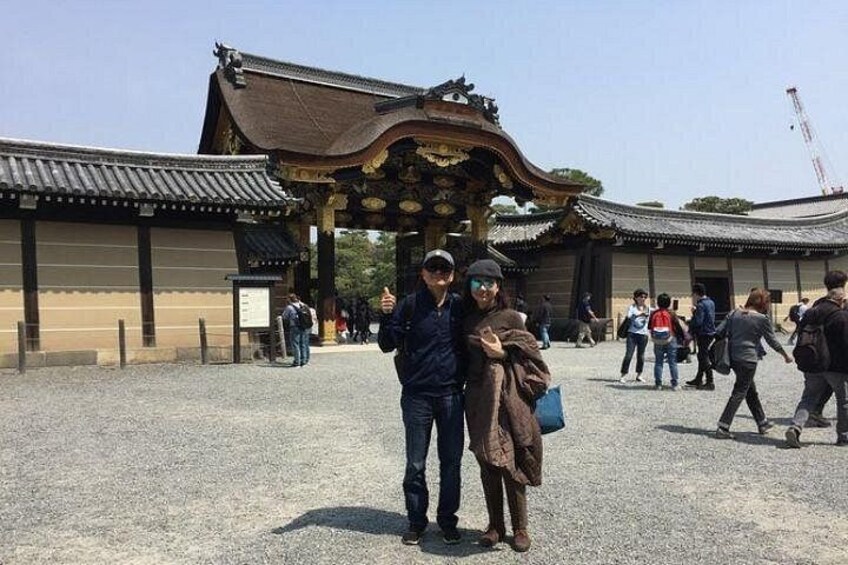A traditional Japanese gate with visitors in the foreground. 5