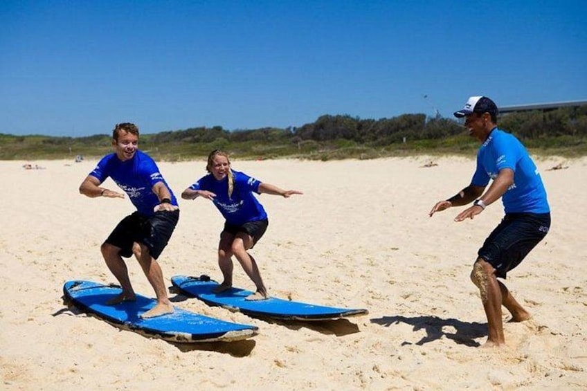Three people on a beach with surfboards. 4
