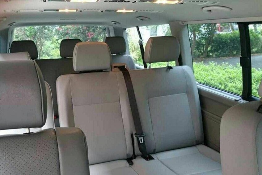 A vehicle interior with beige seats and a sunroof. 2
