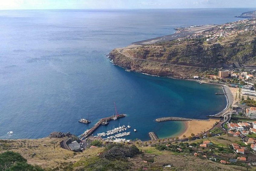 A coastal town with a marina, a lighthouse, and a beach. 3