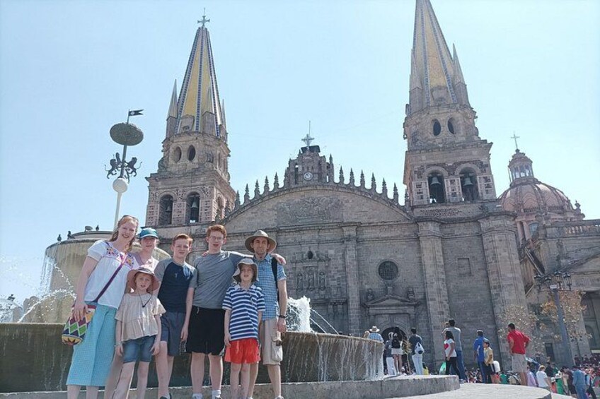 A group of people standing in front of a historic cathedral with two tall spires. 2