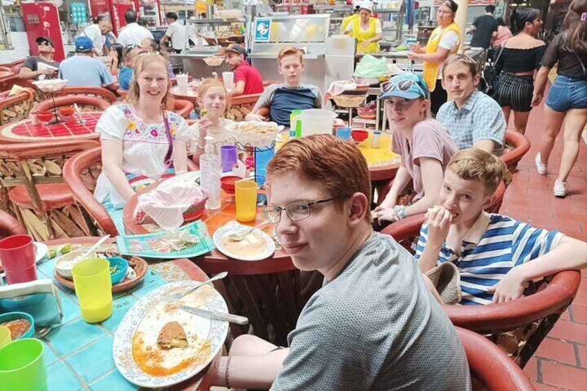 People dining at outdoor tables with food and drinks. 2