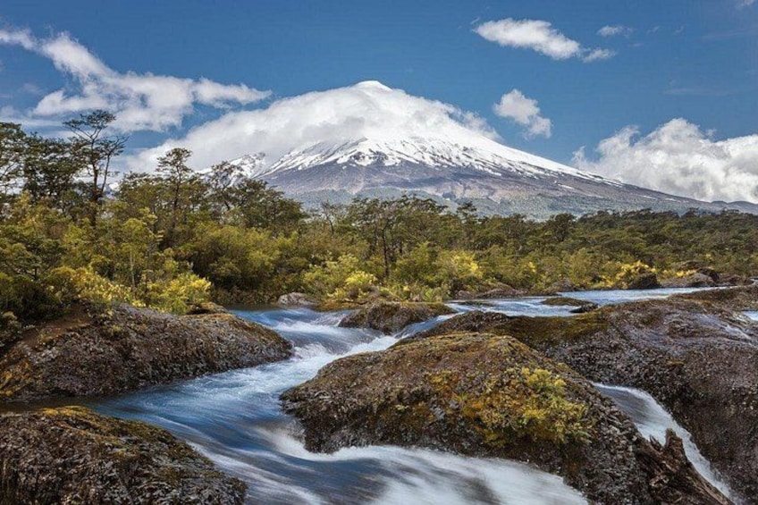 A river flowing through a rocky landscape with a mountain in the background. 1