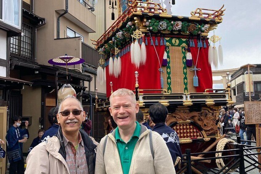 A traditional parade float with ornate decorations and a crowd of people. 3