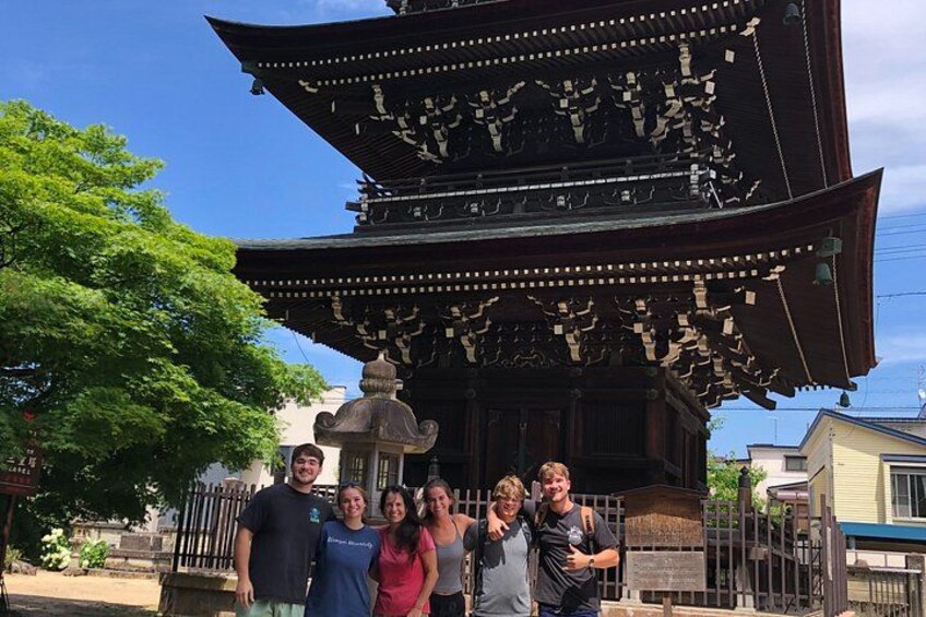 En traditionell japansk pagod med en grupp människor som står framför den. 2